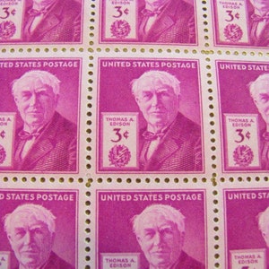 May include: Sheet of vintage United States postage stamps featuring a portrait of Thomas A. Edison. The stamps are a deep magenta color and include the text "Thomas A. Edison" and "3¢". The stamps are perforated.