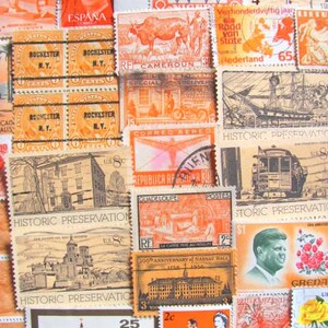 Peut inclure: Une collection de timbres-poste vintage du monde entier. Les timbres présentent une variété de motifs, notamment des animaux, des bâtiments et des personnages historiques. Certains timbres sont orange, rouge et bleu. Les timbres sont disposés de manière aléatoire.