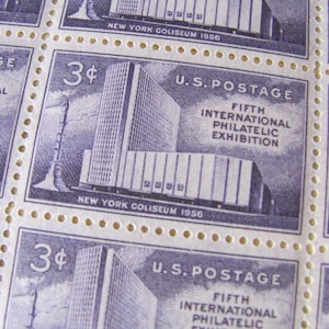Puede incluir: Un sello postal estadounidense vintage de 3 centavos con una ilustración azul y blanca del Coliseo de Nueva York, con el texto "FIFTH INTERNATIONAL PHILATELIC EXHIBITION" y "NEW YORK COLISEUM 1956".