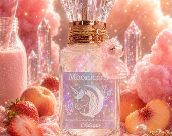May include: A perfume bottle with a crystal stopper and a gold collar, featuring a pink unicorn charm. The label says "Moonicorn" with a unicorn design. Strawberries, peaches, and a pink drink are in the background.