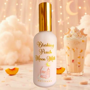 Könnte beinhalten: Eine zylindrische Flasche mit mattem, hellrosa Finish und einem glänzenden goldenen Verschluss. Der Text "Blushing Peach Moon Milk" ist in goldener Schreibschrift aufgedruckt, ergänzt durch eine kleine Illustration eines Milchkartons mit Schweinegesicht.