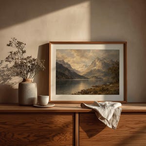 Peaceful mountain lake artwork featuring dense treeline and dramatic lighting — timeless landscape print