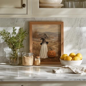 Charming spooky autumn wall art featuring spectral figure beside carved gourd in quiet rolling farmland