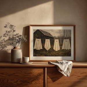 Sheet ghost hanging artwork for seasonal display — cozy spooky farmyard scene with bare trees and muted brown tones