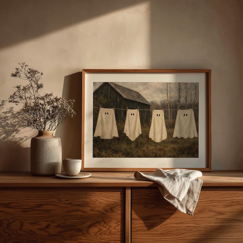 Sheet ghost hanging artwork for seasonal display — cozy spooky farmyard scene with bare trees and muted brown tones