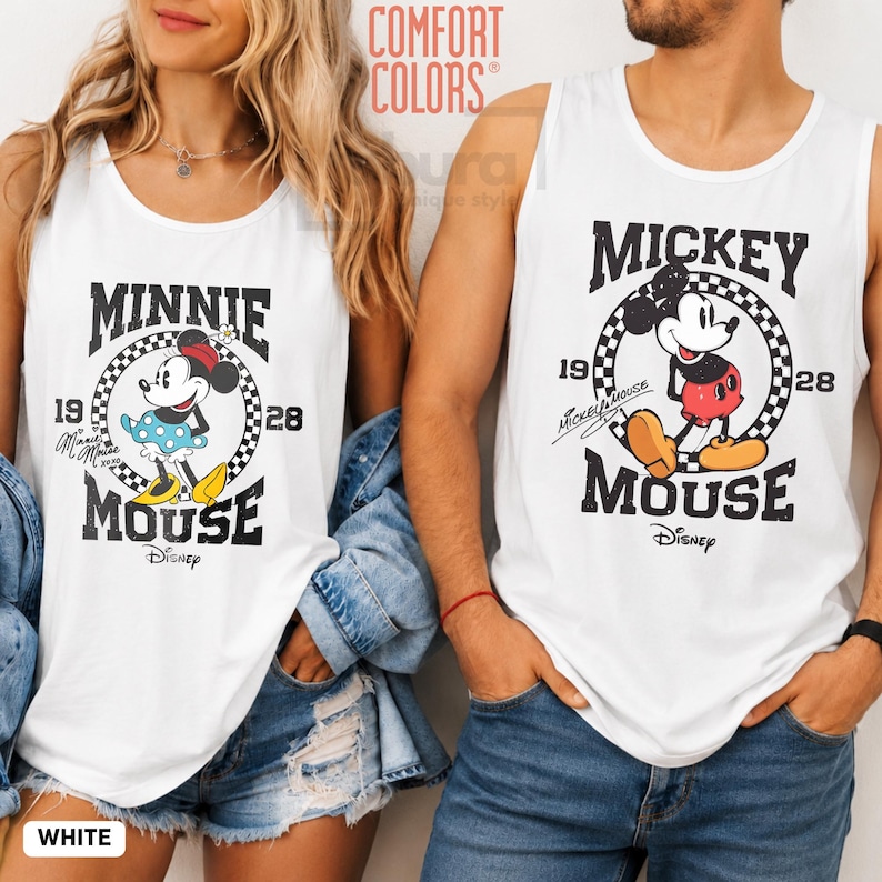 K&ouml;nnte beinhalten: Wei&szlig;e Tanktops mit Minnie- und Mickey-Mouse-Designs. Das Minnie-Mouse-Tanktop hat einen schwarz-wei&szlig; karierten Kreis um Minnie, mit dem Text "MINNIE MOUSE" und "1928". Das Mickey-Mouse-Tanktop hat ein &auml;hnliches Design mit Mickey.