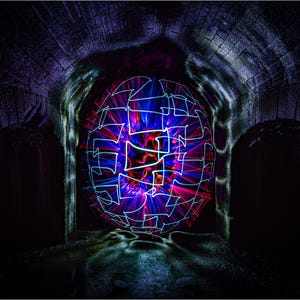 May include: A colorful light painting of a sphere created with long exposure photography in a dark, brick tunnel.