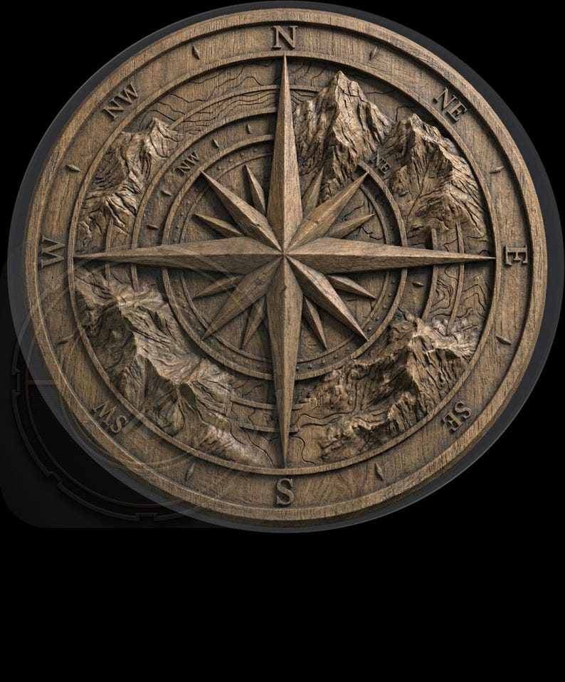 May include: A round, wooden compass rose with a detailed, carved design. The compass features a central star, directional markers (N, S, E, W, NW, NE, SW, SE), and mountain range imagery. The wood has a natural, warm brown tone.