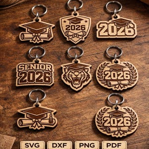 Peut inclure: Ensemble de porte-clés en bois découpés au laser sur le thème de la remise de diplômes. Chaque porte-clé présente une coiffe de diplômé et l'année 2026. Le texte "Laser Cut Keychain Designs" et "6 Designs Bundle" est également visible.