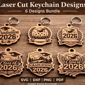 May include: A collection of six laser-cut wooden keychains with graduation-themed designs. Each keychain features a graduation cap and the year 2026, with various decorative elements like scrolls, laurel wreaths, and wings. The keychains are displayed on a wooden surface.