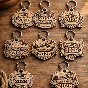 May include: Laser cut keychain designs featuring graduation themes. The image displays a bundle of six wooden keychains, each with a unique design, including the text "Graduation 2026" and "Class of 2026". The keychains are attached to silver keyrings.