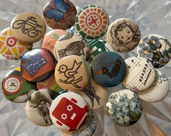 Puede incluir: Una colección de botones redondos y decorativos con varios diseños. Los botones presentan ilustraciones de una bicicleta, mariposa, búho, pájaro, notas musicales y más. La paleta de colores incluye tonos de azul, rojo, naranja y beige.