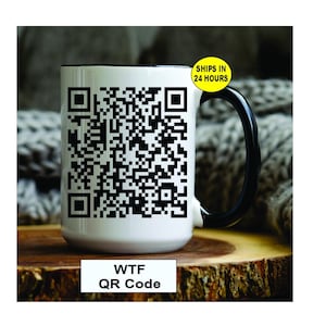 May include: White ceramic mug with a black handle and rim, featuring a large QR code design. The mug has the text "WTF QR Code" at the bottom. A yellow sticker on the handle says "SHIPS IN 24 HOURS".