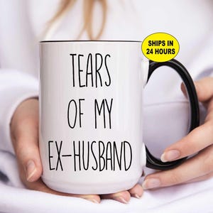 May include: White ceramic mug with a black handle and rim. The mug features the text "TEARS OF MY EX-HUSBAND" in black, handwritten-style lettering. A humorous gift idea.