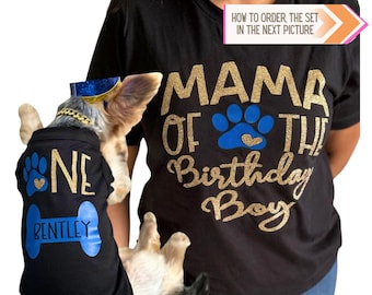 May include: A black t-shirt with gold glitter text reading MAMA OF THE Birthday Boy and a blue paw print with a gold heart. A smaller black pet shirt features the text ONE, a blue paw print, and a blue bone shape with the name BENTLEY.