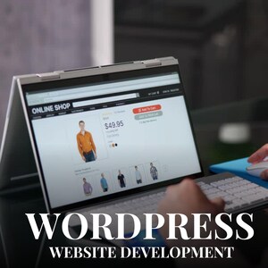 May include: A laptop screen showing an online shop selling a shirt for &pound;49.95. The laptop is open on a desk with a keyboard and mouse. The text "WORDPRESS WEBSITE DEVELOPMENT" is displayed at the bottom of the image.
