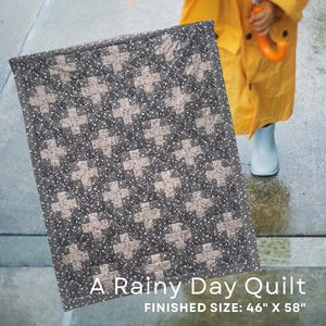 May include: A rectangular quilt featuring a repeating pattern of light grey cross shapes set against a dark grey floral background. The text A Rainy Day Quilt and FINISHED SIZE: 46" X 58" is printed in white at the bottom of the image.