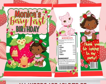 Op de afbeelding: Drie feestelijke cadeauzakjes met een aardbeienthema. De zakjes bevatten illustraties van een baby meisje, een roze kat en de tekst "Monica's Berry First Birthday" en "Thank you for coming to my party!" De zakjes liggen op een wit oppervlak.