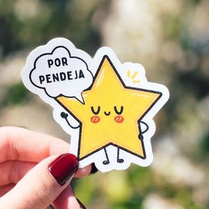 K&ouml;nnte beinhalten: Ein gelber, sternf&ouml;rmiger Aufkleber mit einem l&auml;chelnden Gesicht und rosigen Wangen. Der Aufkleber hat eine Sprechblase, in der "POR PENDEJA" steht.