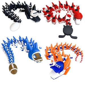 May include: A collection of articulated dragon toys in various colors and sports themes. One dragon is black and white with a rugby cap, another is red and white with a hockey helmet, a third is blue and white with a football helmet, and the last is orange and blue with a baseball cap.