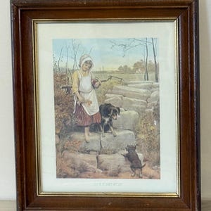 May include: Framed print featuring a young person in a bonnet and apron, holding flowers and an apple, with two dogs on stone steps. The print has a brown wooden frame and the text "THE FIRST STEP" at the bottom.