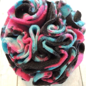 Könnte beinhalten: Ein farbenfroher Fleece-Ball für Haustiere, hergestellt aus schwarzem, rosa und blauem Stoff. Der Ball besteht aus mehreren Stoffschichten, die eine strukturierte Oberfläche erzeugen.
