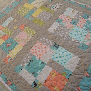 May include: A patchwork quilt with a variety of colors and patterns, including pink, blue, green, and yellow. The quilt is made of squares and rectangles, and the fabric is quilted with a wavy pattern.