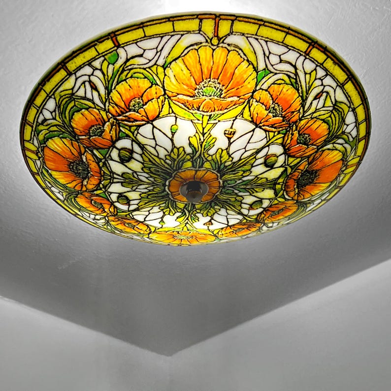 May include: A stained glass ceiling light fixture featuring a floral design with orange and yellow poppies. The light has a circular shape with a yellow border and a central brown fixture.