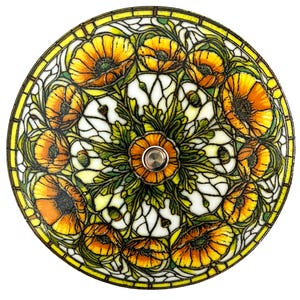 May include: A stained glass lamp shade featuring a floral design with orange and yellow poppies, green leaves, and white background. The shade has a yellow border and a silver center fixture.
