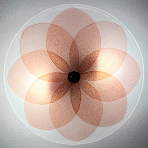 Könnte beinhalten: Eine runde, weiße Deckenleuchte mit einem mattierten Glasschirm. Der Schirm hat ein geometrisches Muster aus überlappenden Kreisen in hellbrauner Farbe, das ein blumenartiges Muster erzeugt.