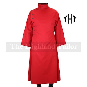 Puede incluir: Un abrigo largo de color rojo vibrante con cuello alto y botones en el lateral. El abrigo tiene mangas largas y un dobladillo hasta el suelo. El texto "The Highland Tailor" es visible en la parte inferior de la imagen.