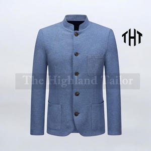 May include: A light blue blazer with a mandarin collar, four buttons, and two front pockets. The jacket has long sleeves and a tailored fit. The text "The Highland Tailor" is visible on the lower left. The logo "THT" is on the upper right.