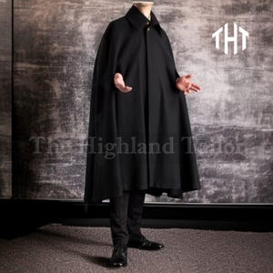 Puede incluir: Una capa negra con cuello y cierre de botones. La capa es larga y fluida, llegando hasta los tobillos. El logotipo de The Highland Tailor es visible en la esquina superior derecha.