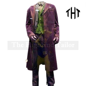 Pode incluir: Um traje teatral com um casaco comprido roxo, colete verde, camisa estampada e calças roxas. A roupa tem um ajuste sob medida. O logotipo The Highland Tailor é visível.