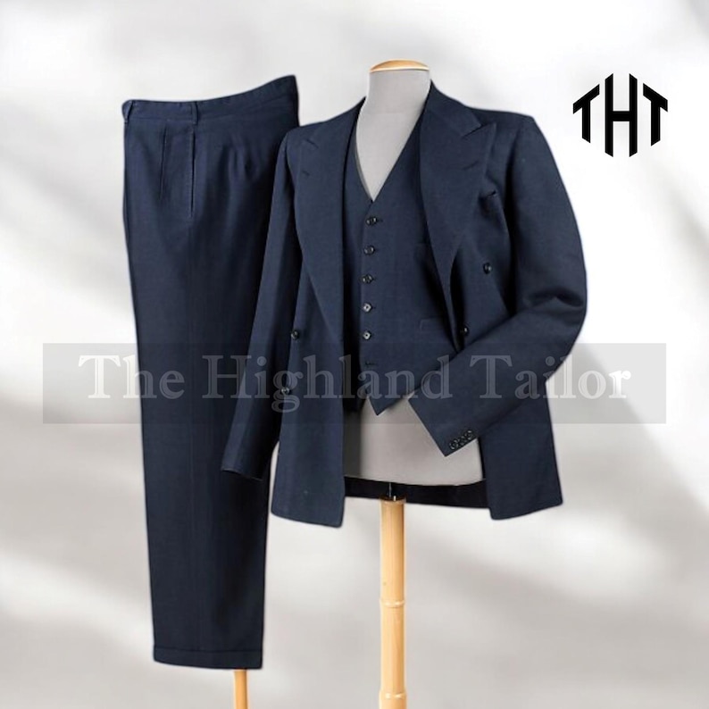 May include: A navy blue three-piece suit displayed on a mannequin. The suit includes a double-breasted blazer, a vest, and matching trousers. The Highland Tailor logo is visible in the upper right corner. The suit is made of a textured fabric.