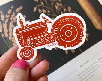 Può includere: Un adesivo di trattore rosso su sfondo bianco. Il trattore è in stile vintage con una sola ruota anteriore e due ruote posteriori. L'adesivo è perfetto per aggiungere un tocco di fascino rurale al tuo laptop, alla tua borraccia o al tuo planner.