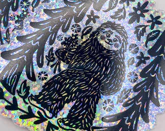 May include: A black and white illustration of a sloth holding flowers, surrounded by trees and flowers on a silver glitter background.