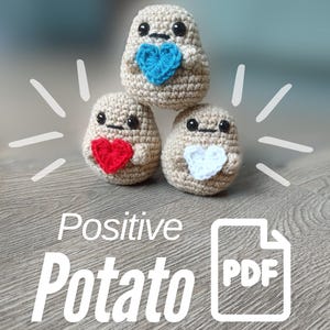 Puede incluir: Tres figuras de crochet con forma de patata, con caras sonrientes y detalles de corazón. Una patata tiene un corazón azul, otra un corazón rojo y otra un corazón blanco. El texto "Positive Potato PDF" se muestra debajo.