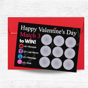 May include: A Valentine's Day scratch-off card with the text "Happy Valentine's Day Match 3 to WIN!" on a black background. The card includes icons and phrases like "Blowjob," "Lap dance," "Massage," and "Anal." The card is set on a red envelope.