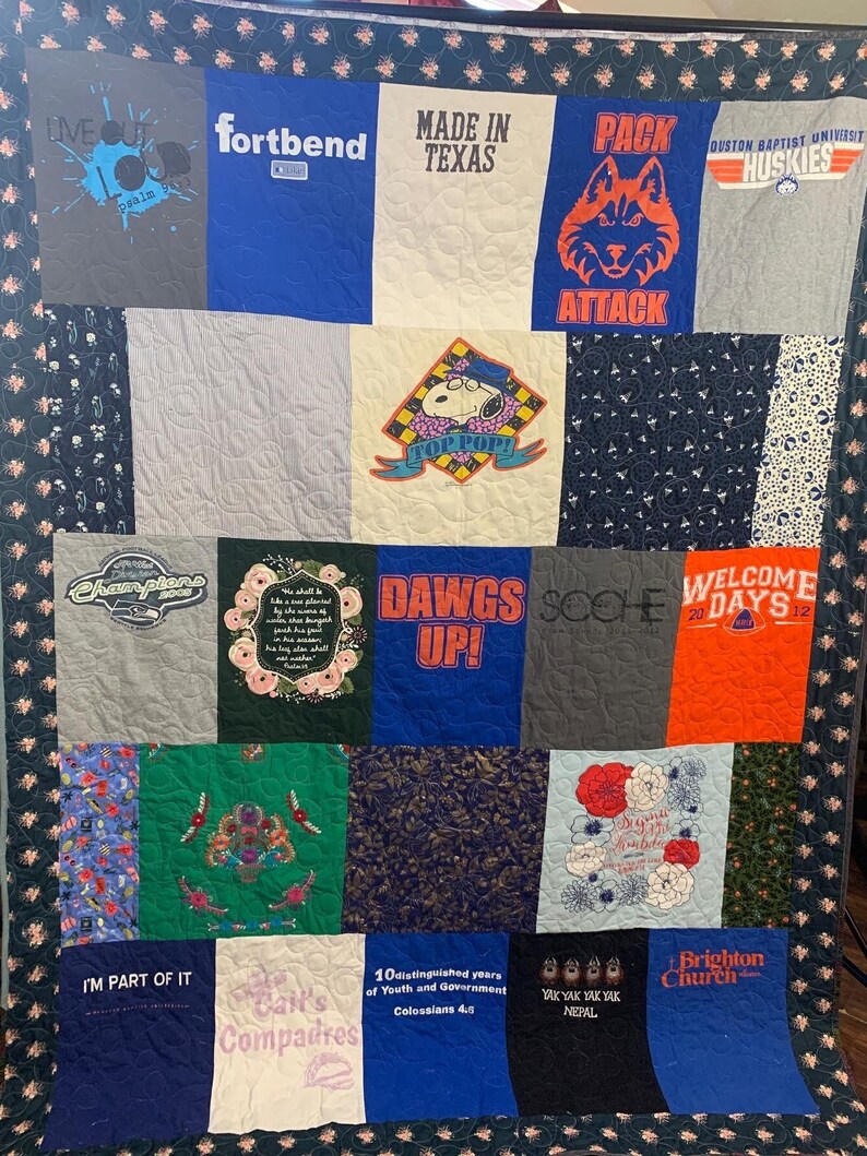 以下が含まれることがあります： さまざまなTシャツで作られたキルトで、さまざまなデザインとテキストが特徴です。キルトは16個の正方形で構成されており、それぞれ異なるデザインです。デザインには、オオカミ、犬、花、教会などがあります。キルトのテキストには、「パックアタック」、「ドッグスアップ！」、「ブライトンチャーチ」などがあります。