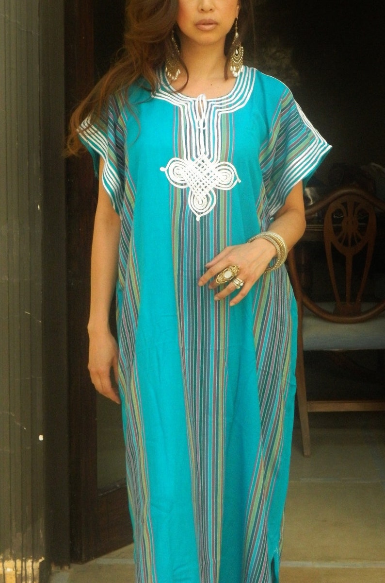 May include: A turquoise and white striped dress with white embroidery. The dress has short sleeves and a round neckline.