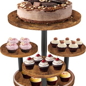 Puede incluir: Un soporte para pasteles de varios niveles que muestra un gran pastel de chocolate cubierto con galletas y chocolates, y varios niveles de cupcakes. Las magdalenas tienen varios ingredientes, incluyendo cerezas, crema y nueces. El soporte es de madera y metal.