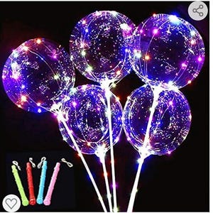Puede incluir: Cinco globos de plástico transparente con luces LED de colores en su interior. Los globos están unidos a palos blancos. Los palos están agrupados y listos para ser utilizados en una fiesta o celebración.