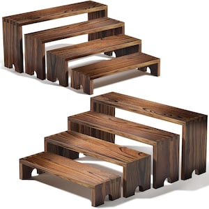 Puede incluir: Conjunto de elevadores de exhibición de madera de varios tamaños. La madera marrón oscura muestra vetas visibles. Cada elevador tiene una parte superior rectangular y patas en forma de bloque. Ideal para exhibiciones.