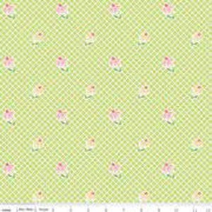 May include: A fabric with a light green background featuring a grid pattern. Small pink and yellow floral designs are scattered across the fabric. The fabric is likely cotton or a similar material, suitable for quilting or crafting projects.