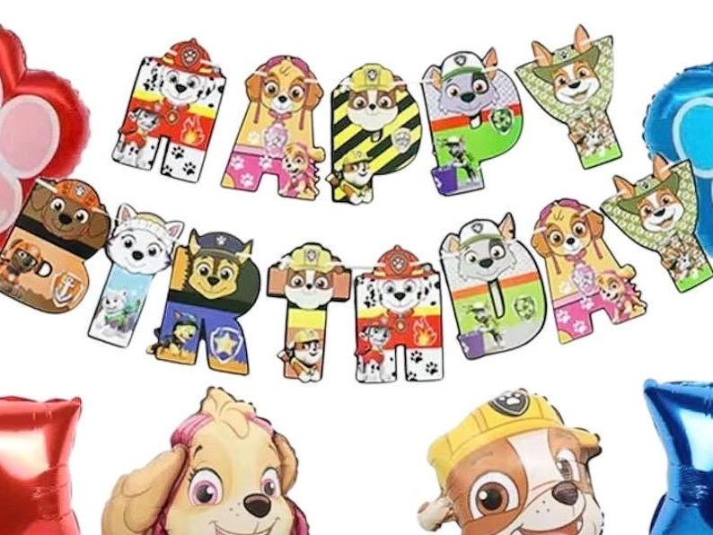 May include: A colorful "Happy Birthday" banner featuring cartoon dog characters. The letters are decorated with images of the dogs in various poses and outfits. Balloons in red and blue are also visible.