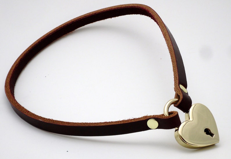 May include: A brown leather choker with a brass heart-shaped padlock attached.