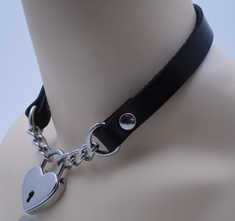 May include: A black leather choker with a silver heart-shaped padlock and chain.