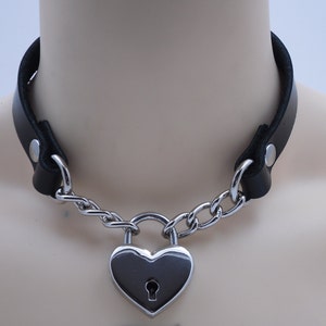 May include: A black leather choker with a silver chain and a heart-shaped padlock.