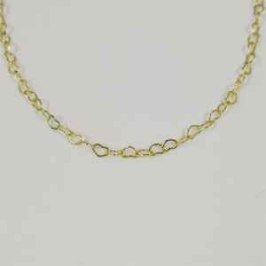 May include: A gold-toned chain necklace featuring a series of small, interconnected heart-shaped links. The delicate metal links form a continuous, repeating pattern throughout the length of the chain, creating a uniform and lightweight appearance.